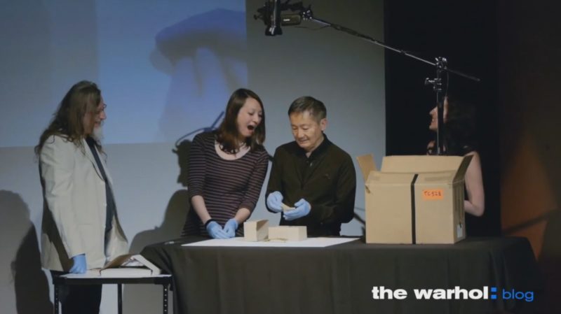 Four people including Andy Warhol's former personal and studio assistant Benjamin Liu view a Warhol time capsule's contents.