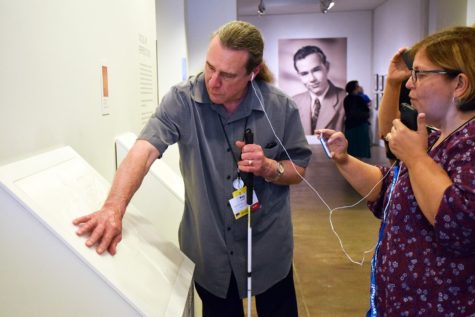 A low vision Warhol Museum visitor uses the Out Loud audio guide.
