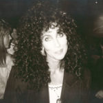 Singer and actress Cher in the 1980s smiling at the camera.
