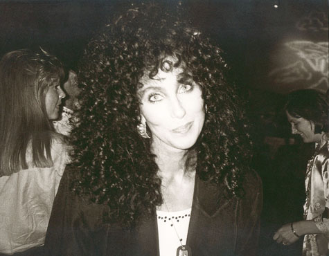 Singer and actress Cher in the 1980s smiling at the camera.