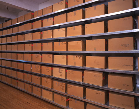 Warhol's Time Capsules, packaged in cardboard boxes and arranged on shelves.