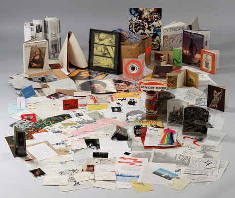 The contents of one of Andy Warhol's time capsules. Mostly papers, some photographs, small books, and pieces of art.