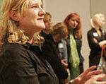 A clapping woman stands among a group of attendees at the opening of the Warhol: Immortal exhibit in New Zealand.