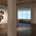 View of the inside of the Warhol museum showing Warhol's dollar sign prints on one wall and pistol screen prints on the other.