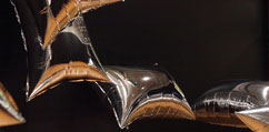 Rectangular silver mylar balloons float against a dark background.