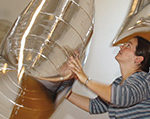 A museum volunteer handles large rectangular mylar balloons for an interactive space.