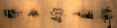 This is in image of one of Andy Warhol's oxidation prints. The canvans, which is longer horizontally than vertically, is coated with copper paint. There are five oxidized areas evenly spaced across the center of the canvas. They range in color from black to brown to green, and a few of them drip towards the bottom of the canvas.