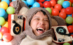 Close up of a man wearing a koala suit in a colorful ball pit