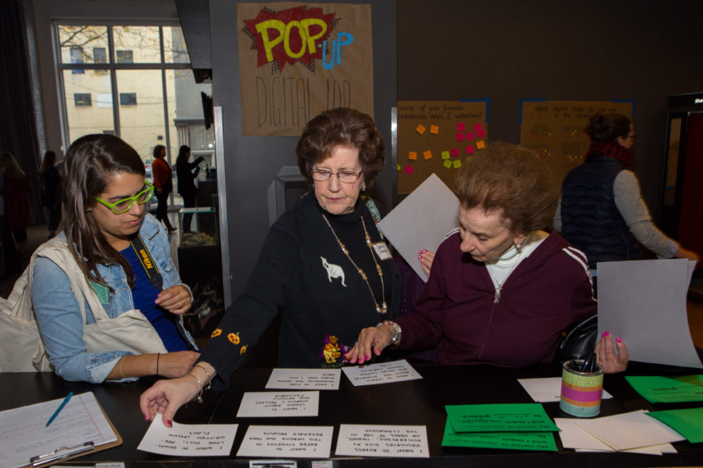 Three people participate in the card-sorting activity at the Pop-Up Digital Lab