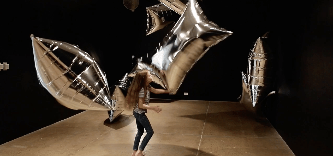A girl plays with silver balloons in the Silver Clouds gallery of The Andy Warhol Museum.