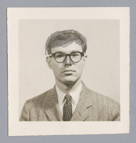 A photograph of young Andy Warhol wearing a suit and tie as well as his round glasses. He has colored over his hair and slimmed the sides of his nose in silver cross-hatching.