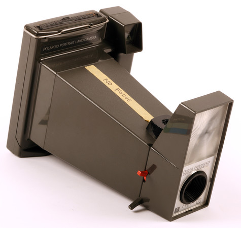 A Polaroid camera with a piece of tape on its side that reads No Focus.