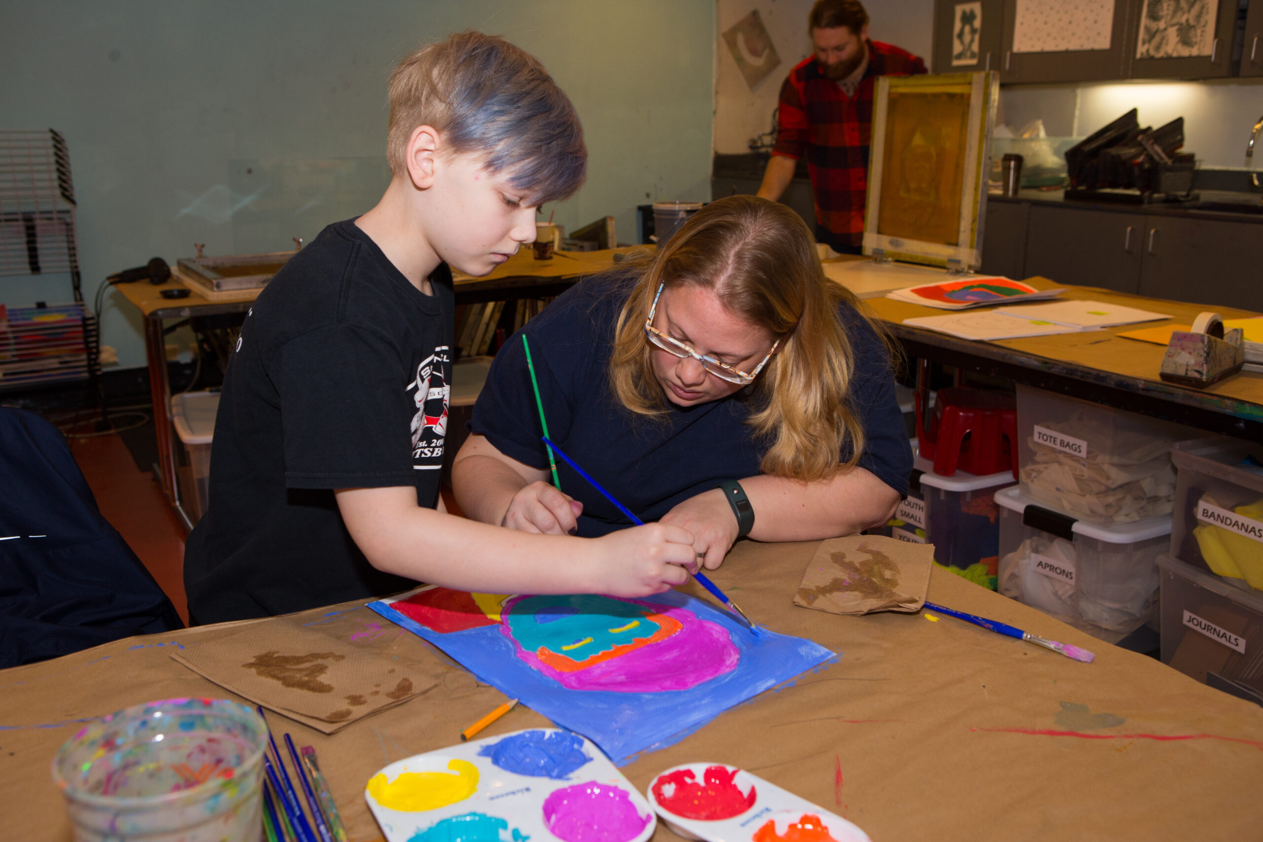 A child and an adult work on a Warhol-inspired painting in The Factory, the museum's underground studio.