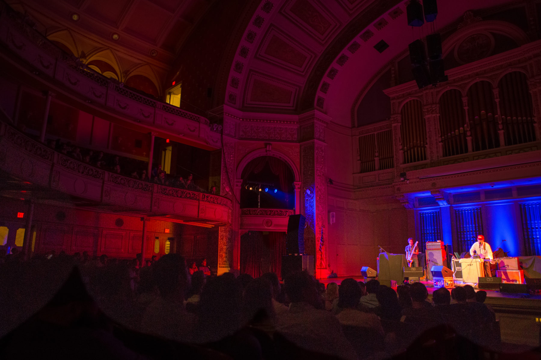 A photograph of the Carnegie music hall during a Sound Series event featuring Yo La Tengo and Lambchop. The seats of the ornate old building are filled.