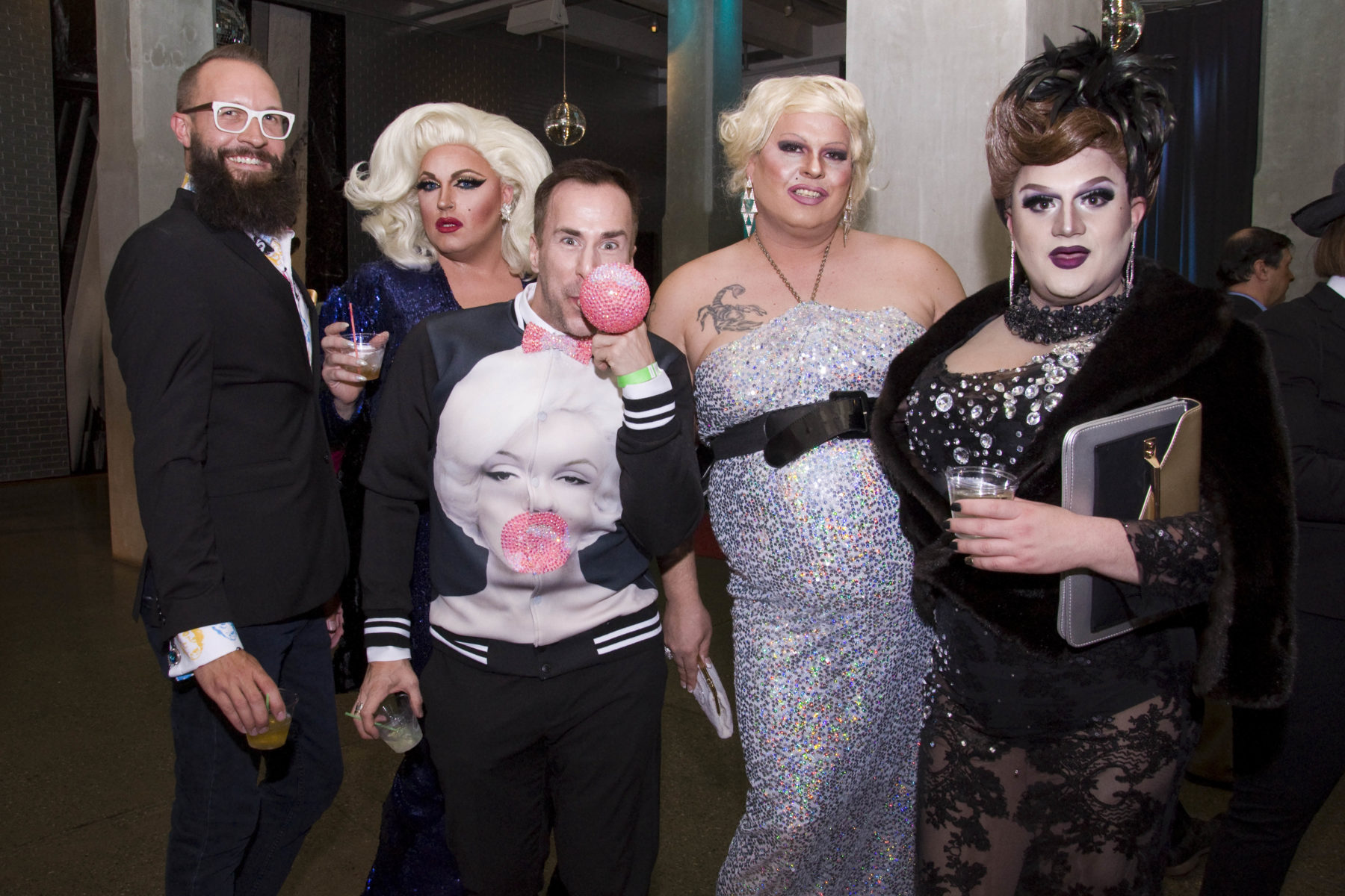 Two guests pose for a photograph with three of the evenings Marilyn inspired drag performers.