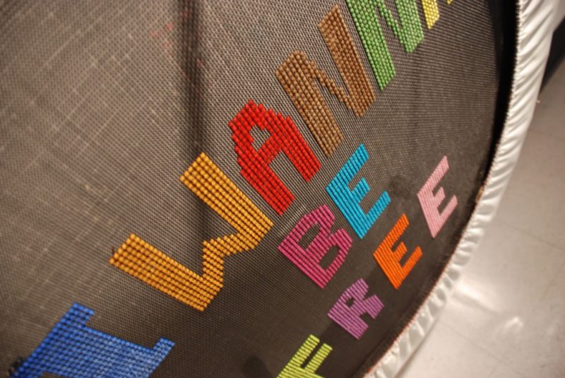 Close up of a small trampoline with the words I wanna be free sticked with bright colors into the material.