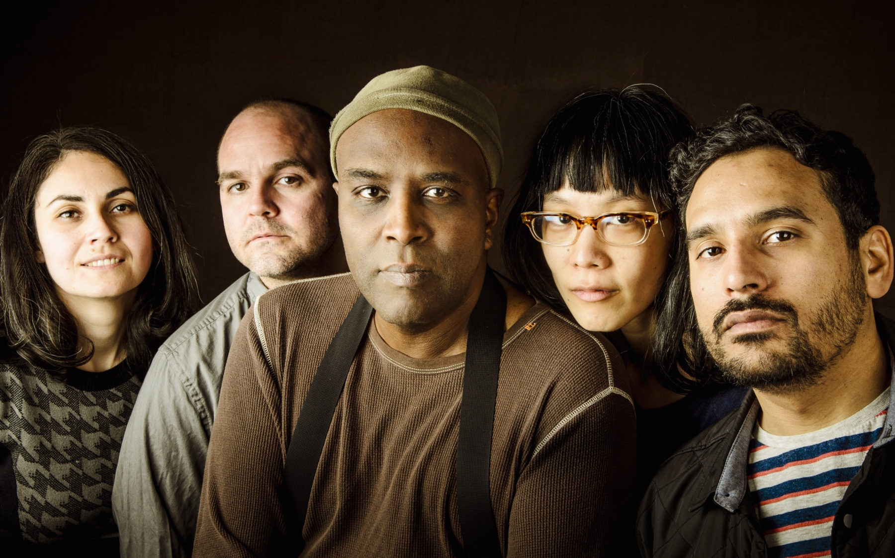 The band Beauty Pill; five people in a row against a black background.