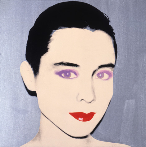 A screen printed portrait of Tina Chow against a silver background. Chow’s skin is pale peach, a stark contrast to the deep black of her hair and eyebrows, the lavender of her eyes, and the cherry red of her lips.