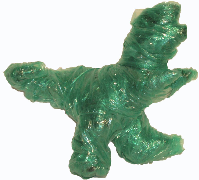 A toy dinosaur wrapped in green cellophane.