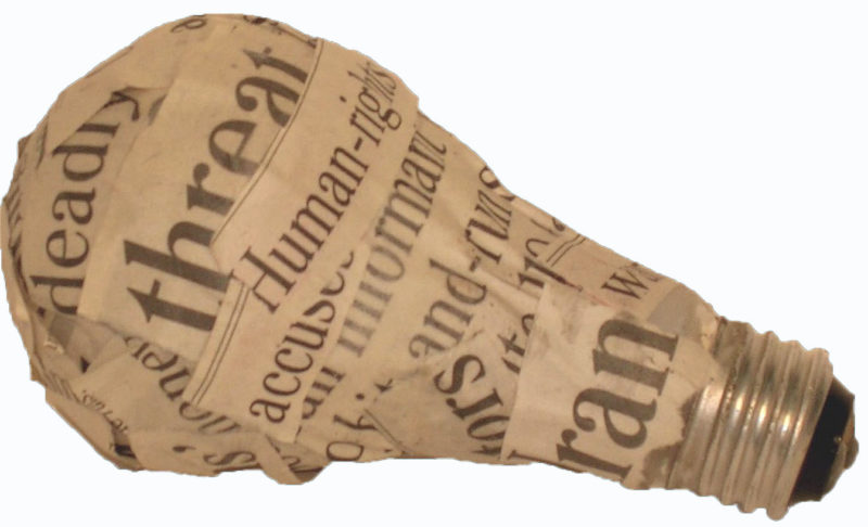 This image shows an incandescent light bulb wrapped with words cut from newspaper headlines laying on its side.