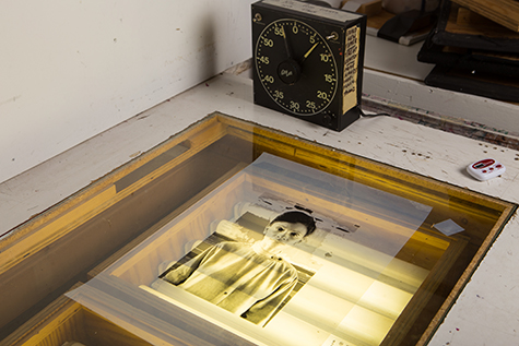 This is an image of a film positive on top of a light table. The light table had four fluorescent lights underneath a glass top. There is a black clock timer in the background.