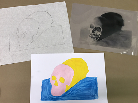This image shows a film positive with a human skull on it in the upper right hand corner. Next to it in the upper left hand corner is a pencil tracing of the skull image on white paper. Below that, in the foreground is the same tracing of the skull painted with acrylic paint. The skull is pink, the shadow is yellow, and the ground is blue.