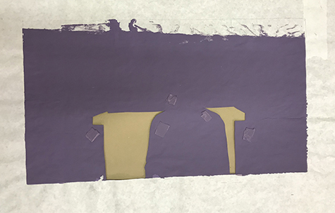 This image shows a used paper stencil with two shapes cut out. The stencil has been printed over in purple ink and has five small pieces of masking tape on it.