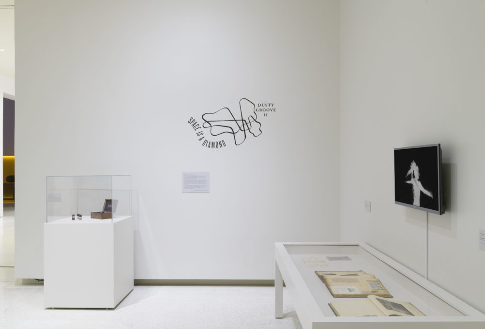 A gallery with white walls that includes various artwork installations.