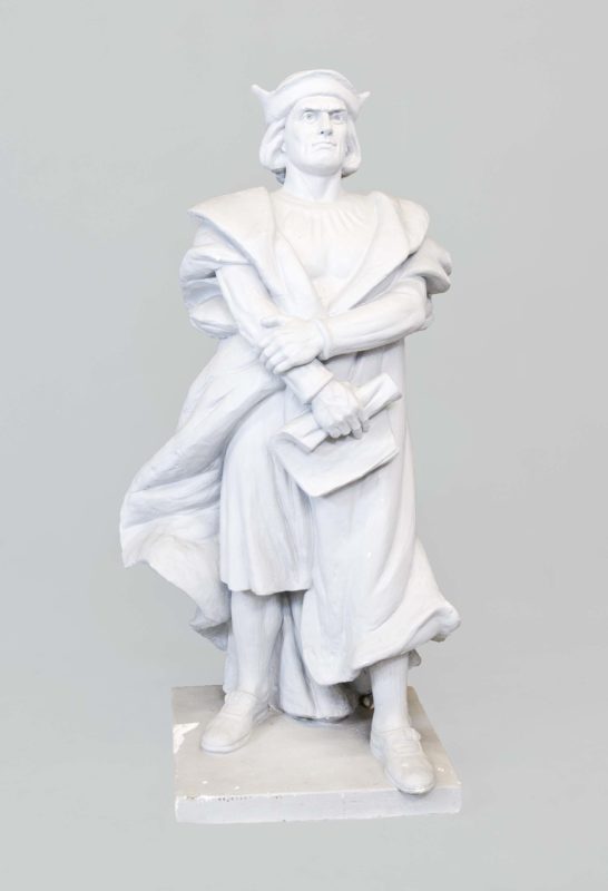 Front view of a plaster cast of Christopher Columbus in traditional robes.