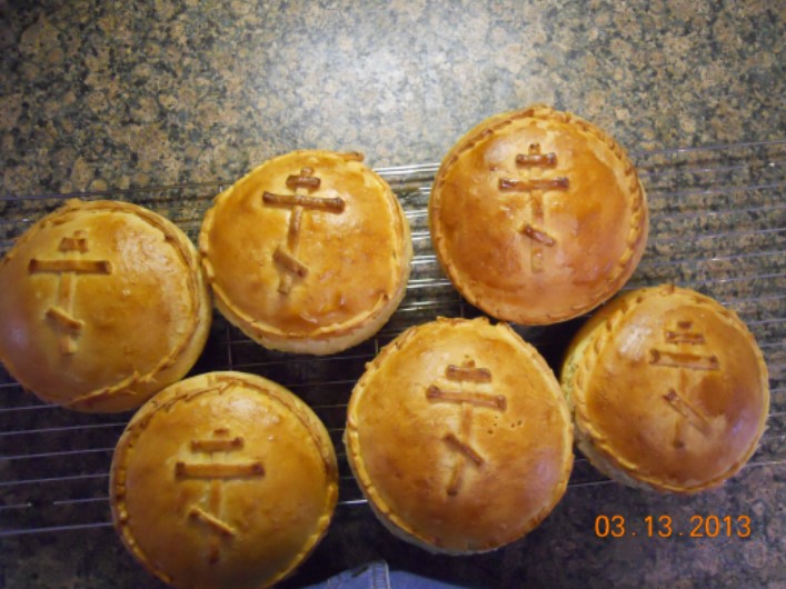 Six loaves of paska, baked and browned, with a three-bar cross in the middle.
