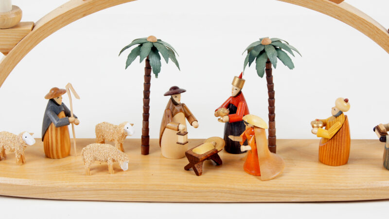 Close-up image of Schwibbogen figurines gathered around a manger.