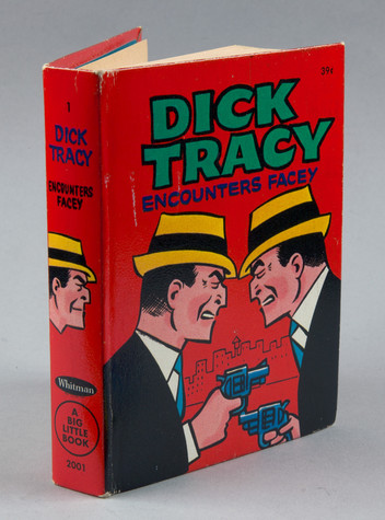 Front view of a red book titled “Dick Tracey Encounters Facey”. The cover image shows a highly-stylized comic book version of two men wearing dark suits and yellow hats facing one another while pointing guns.