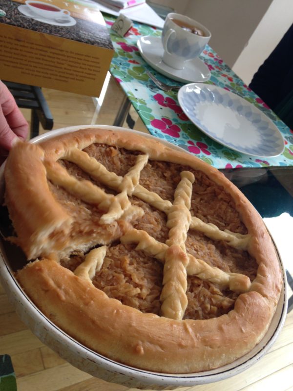 Photo of the first slice being removed from a full, baked apple pirog.