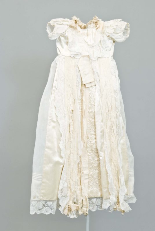 Front view of white and cream baptismal gown made of lace and silk.
