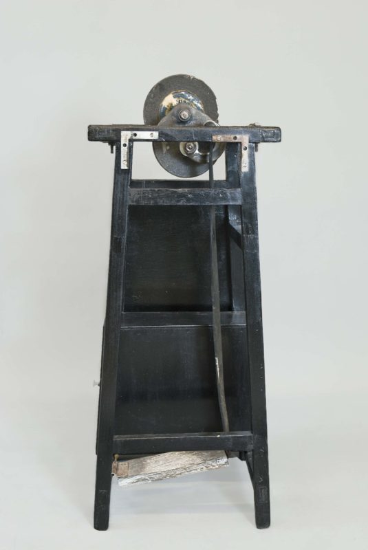 Front view of blade-sharpening machine. The machine is painted black and is standing upright.