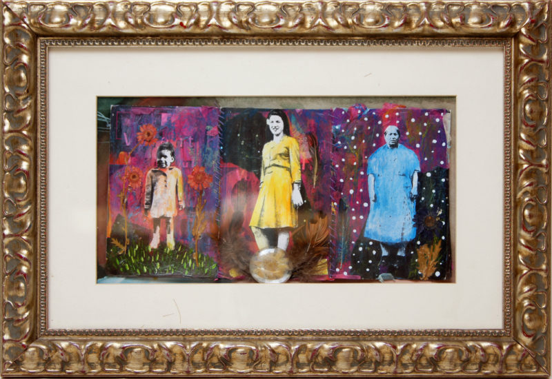 Front view of a framed piece of artwork. The artwork is a triptych of three figures: a child, a young woman, and an older woman.