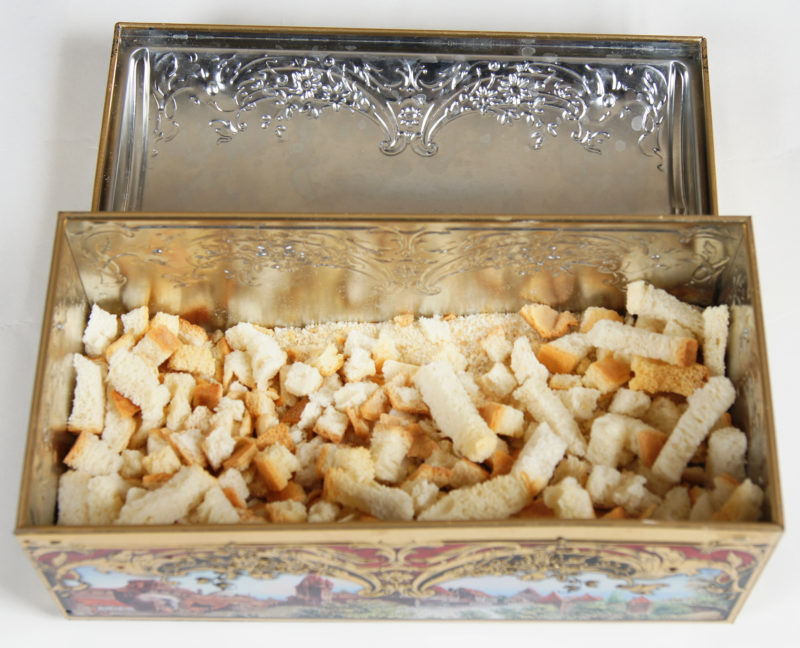 Above view of an opened tin box with rusks (cooked bread pieces).