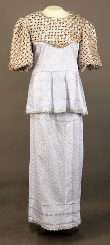 Full frontal view of Kaba made with white satin and a gold-colored woven bodice with puffy sleeves. The Kaba is full-body length.