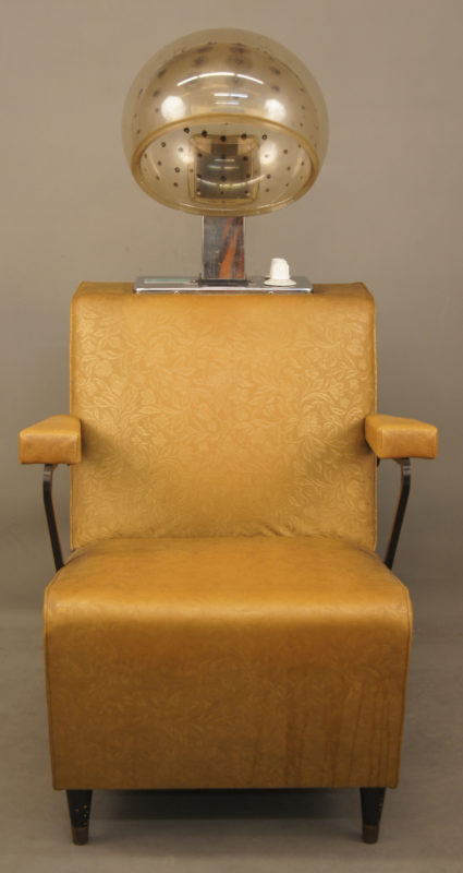 Front view of salon chair with attached dryer. The chair is marigold and has a floral pattern.