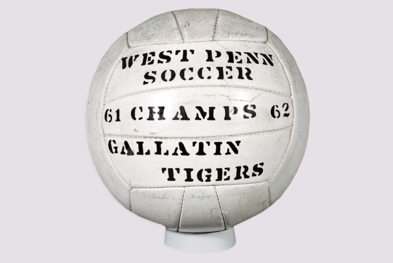 Front view of soccer ball inscribed with a championship title for the 1961-1962 year. The soccer ball also reads “West Penn Soccer” and “Gallatin Soccer.”