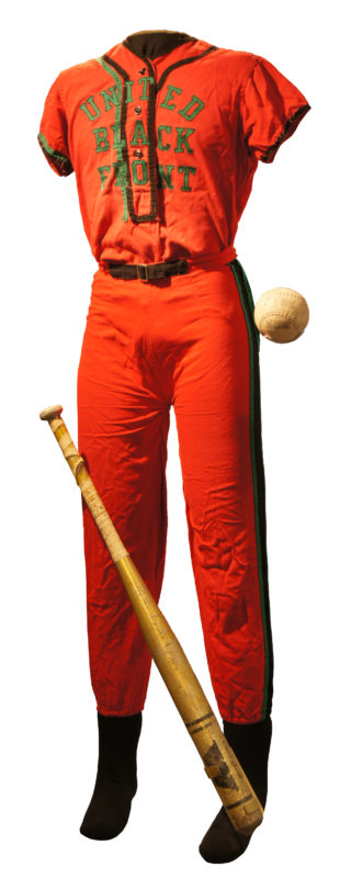 Front view of softball uniform that is red with black accents, and reads “United Black Front” in green. The image also contains a baseball bat and baseball from 1970.