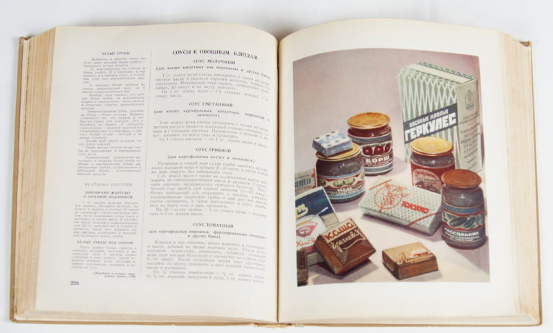 View of cookbook open to a page with instructions in Russian on the left page, and a realistic illustration of boxed and jarred food on the right page.