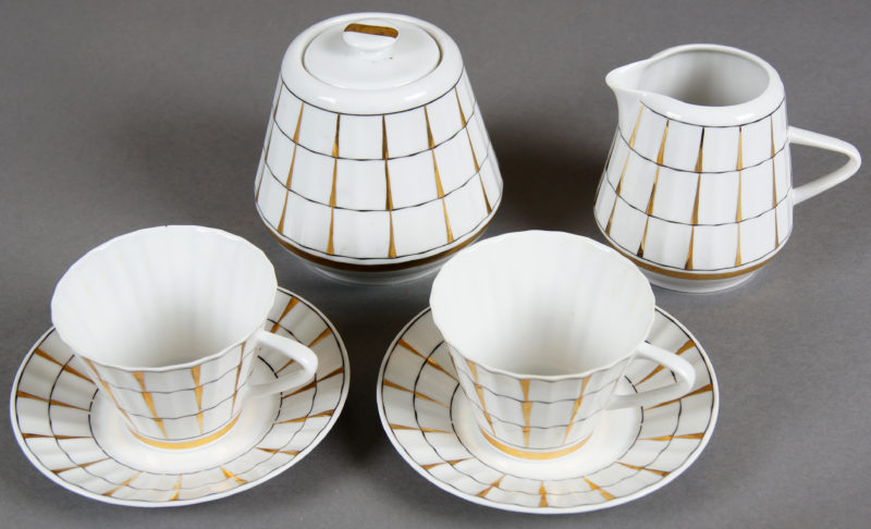 Photo of white and gold checkered, porcelain cups with saucers