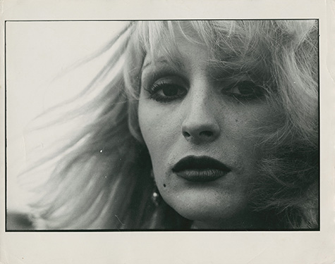 Black and white photograph of a closeup of a person's face. They are looking at the camera.