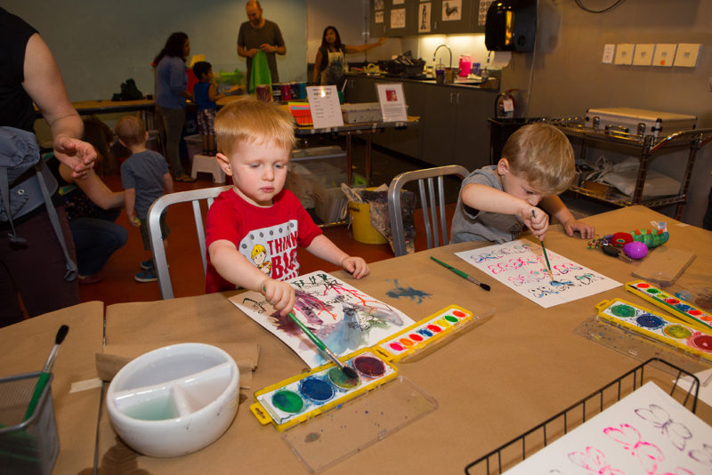 Two children are watercolor painting together.