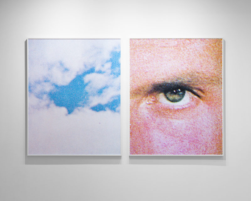 Two portrait-oriented rectangular images hang side-by-side. On the left is an image of white clouds mostly covering a blue sky. On the right is a close-up of an eye looking towards the viewer.