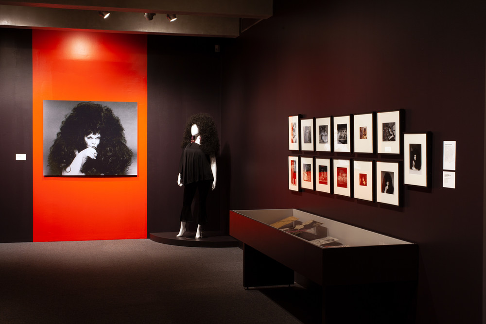 Wide-shot of an exhibition about Tally Brown, including photographs of Tally Brown, including photographs, paraphernalia, and a mannequin dressed in her likeness