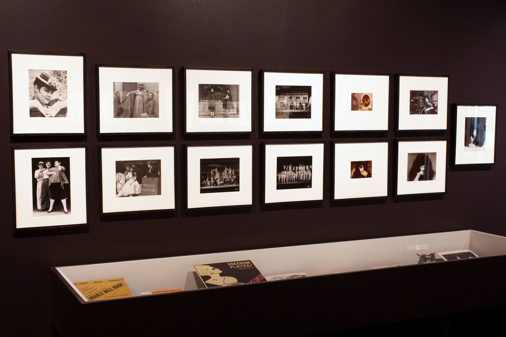 Two rows of photographs of Tally Brown, including portraits and theatrical stills, hangs on a dark wall