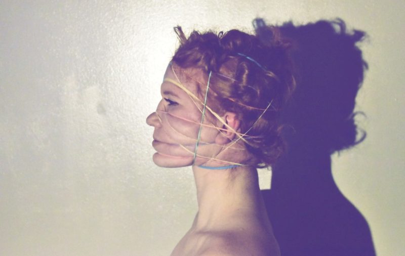 A color side profile of a person with string around their face