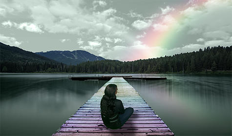 A person sitting on a colorful dock looking out into the water